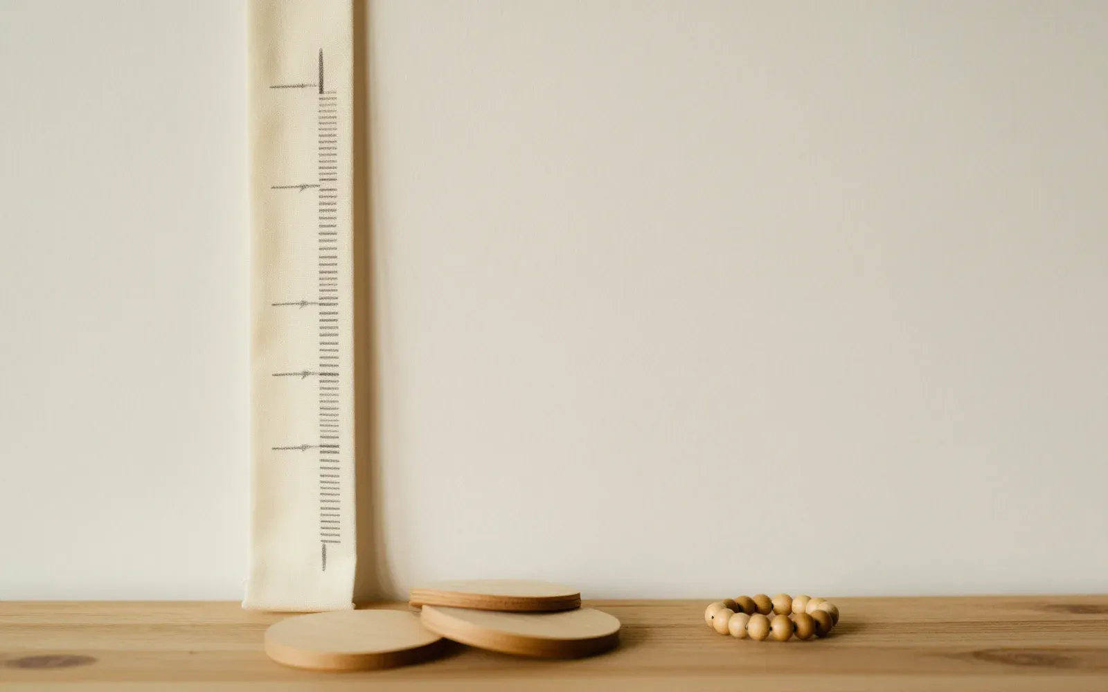 DearBaby growth tracking and First 50 Words, shown with a height ruler and wooden toys