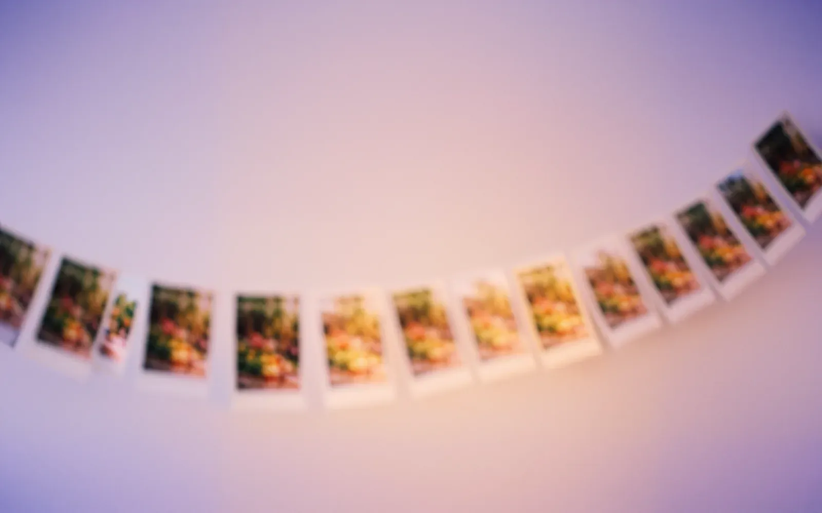 A sweep of DearBaby photo prints in motion, representing a year replayed